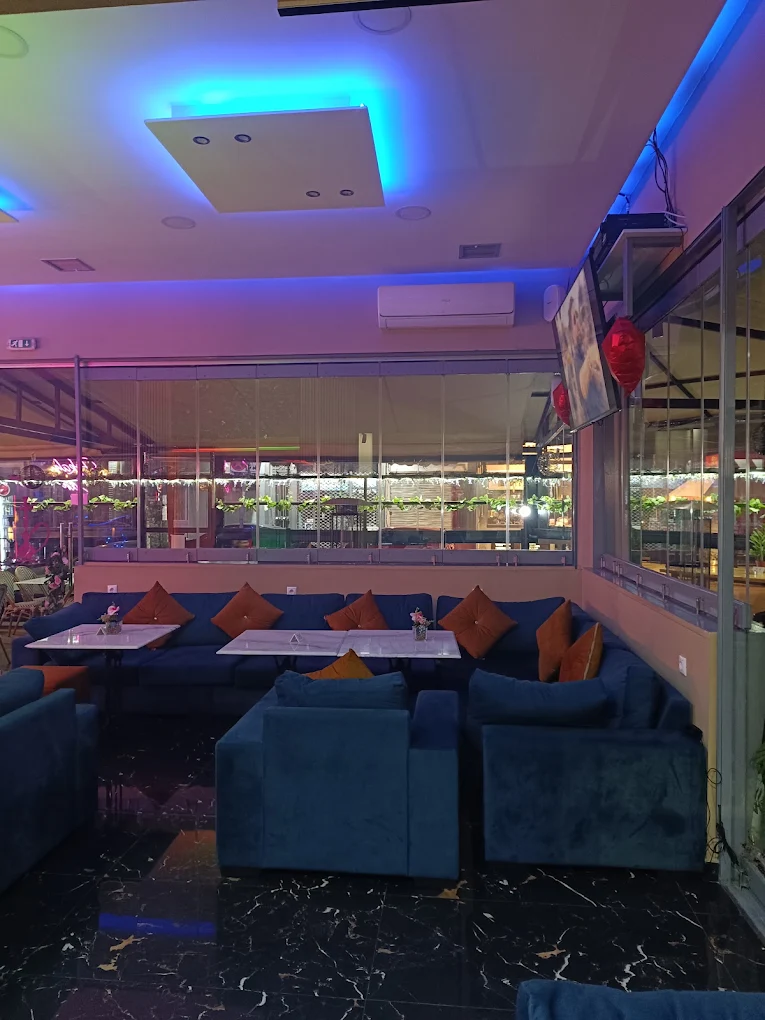Blue velvet lounge seating under blue neon lighting at Amroo Shisha in Piraeus